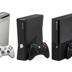 Trzy konsole Xbox 360 w różnych kolorach i wersjach, z kontrolerami. Pamiętasz, kiedy wyszedł Xbox 360?