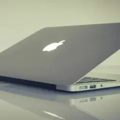 Srebrny laptop Apple z podświetlanym logo. Dowiedz się, jak zrobić zrzut ekranu na laptopie.