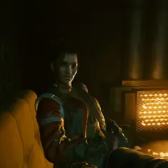 Panam z Cyberpunk 2077 siedzi na kanapie, ogrzewając się przy piecyku.