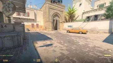 CS2 stuttering na mapie Dust II. Żółty samochód i skrzynie w słońcu.